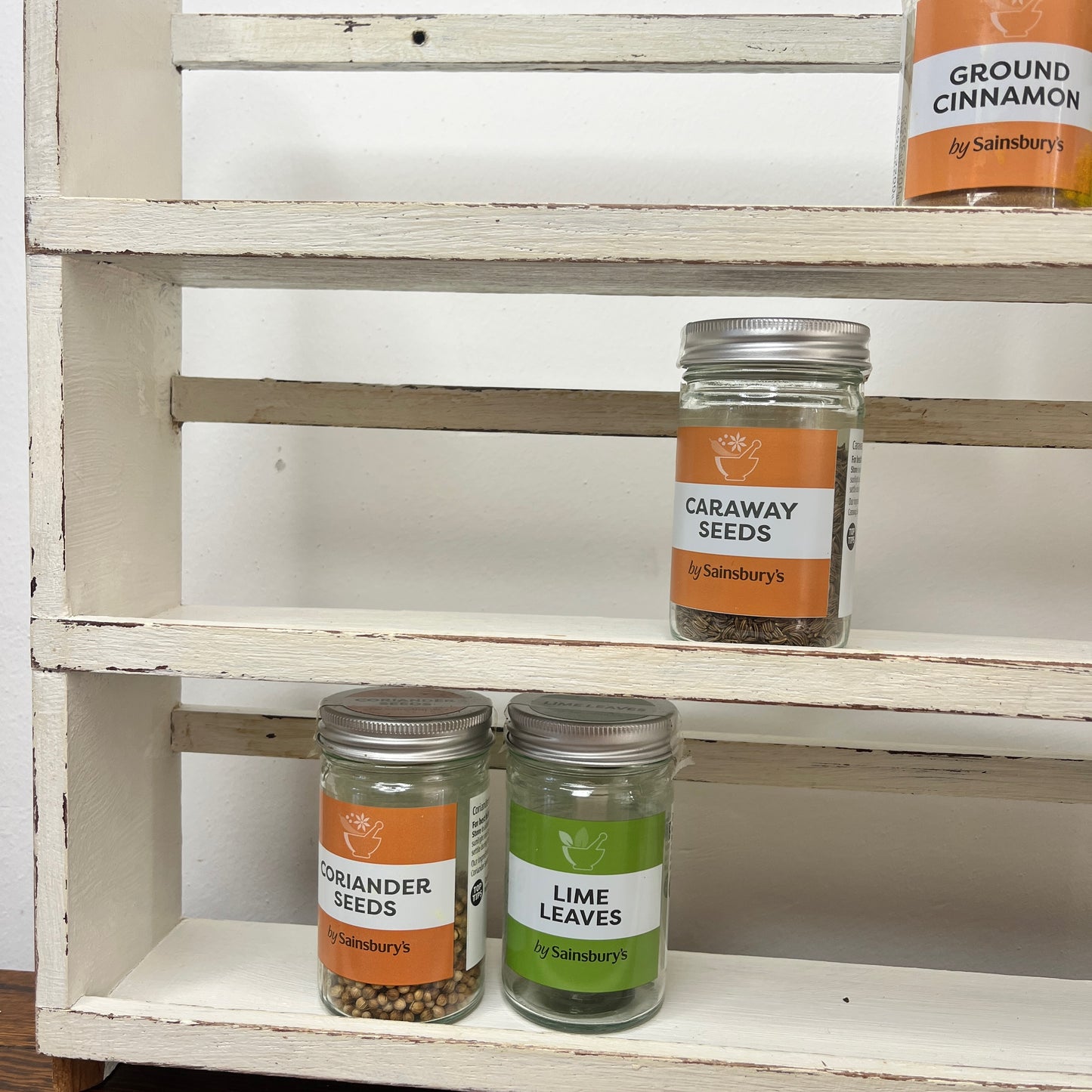 vintage white spice rack with 3 shelves which has become distressed over time