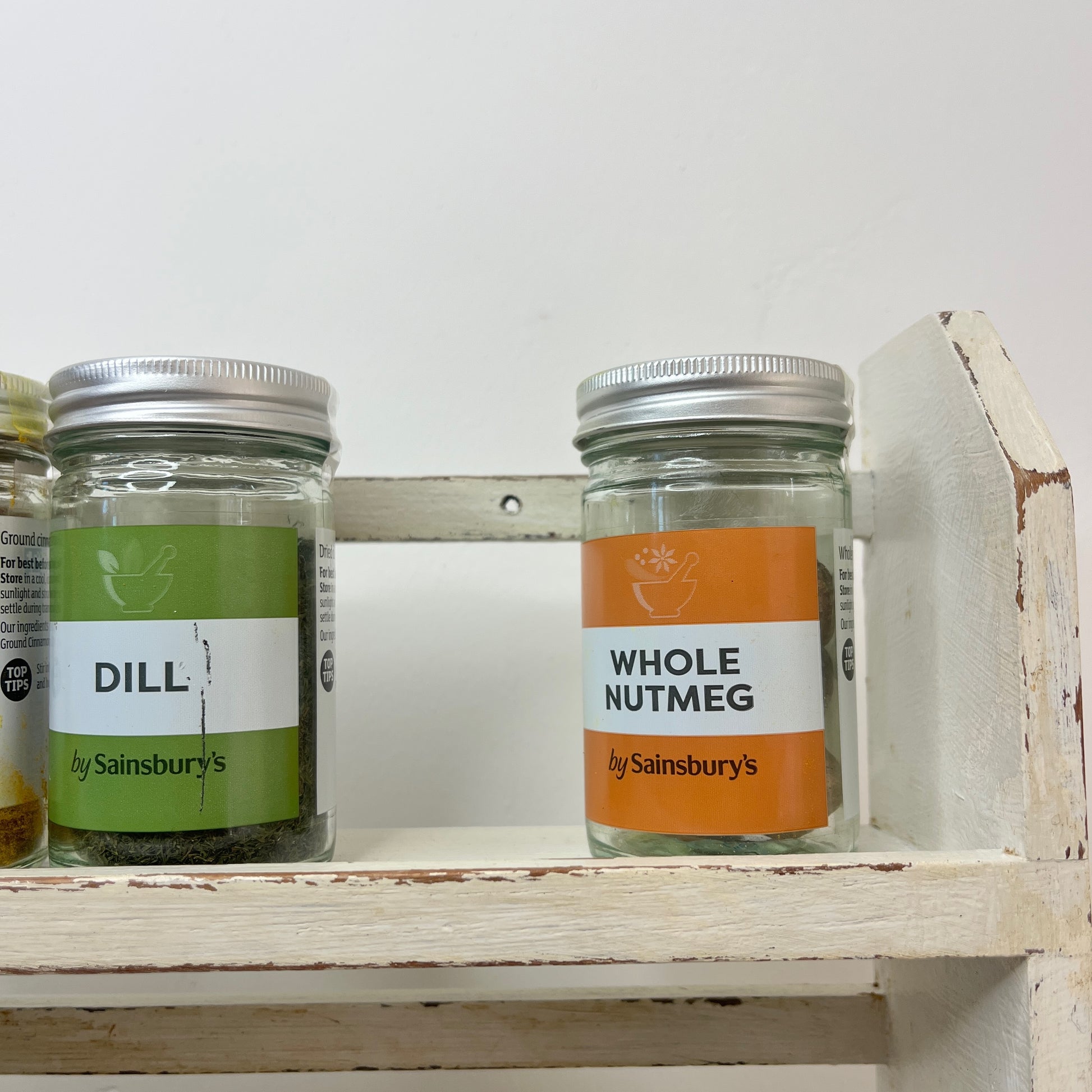vintage white spice rack with 3 shelves which has become distressed over time